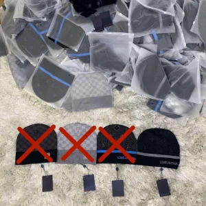 Svart mössa med grå kant - Snygg svart mössa med diskret monogrammönster och grå kant. Broderad logga framtill och klassisk tag. Perfekt accessoar för dig som vill ha en exklusiv och stilren look under kalla dagar. Det finns bara 1 kvar!