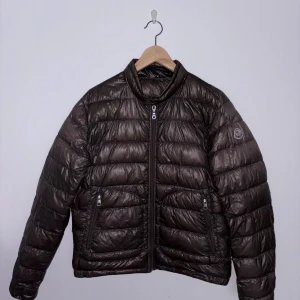 Moncler Acorus - Moncler Acorus  Size: 2(M), Passar S.  Cond: 3/10  En hel del oljefläckar och små hål, varav två lagade.  Några trådar har gått upp. Har bytt dragaren på löparen då den förra gick sönder.
