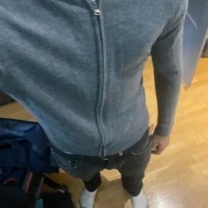 Grå merinoullskofta These Glory Days - Säljer en stilren grå kofta från These Glory Days i mjuk superior merinoull. Koftan har hel dragkedja framtill, långärmad passform och ribbade muddar. Perfekt för lager-på-lager och funkar till både jeans och chinos.