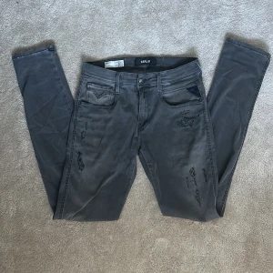 Replay Anbass jeans - Jag säljer ett par riktigt feta gråa replay anbass jeans med riktigt fräscha slitningar som verkligen lyfter plagget. Jeansen är i en lite mörkare grå ton. Jag säljer jeansen för att de helt enkelt inte kommer till så stor användning längre. Jeansen är i storlek 29 alltså Waist 29 och sen även length 34. De är lite för långa på mig men med tanke på att de är långa så kompenserar det för att de är lite smalare så att om man drar upp de så sitter de helt perfekt! Pris kan eventuellt diskuteras.