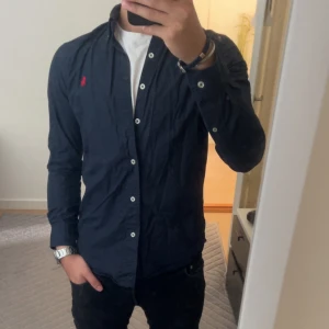 Ralph Lauren skjorta - Mörkblå Ralph Lauren skjorta i väldigt bra skick, den har inga defekter.