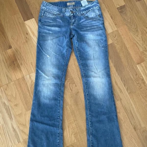Blåa jeans - Supersnygga lågmidjade guess bootcut jeans i färgen blå! Vintage och går inte att få tag på längre! Xs , midja: 36 cm, midjehöjd: 18 cm, innerben: 78 cm