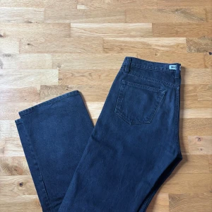 Svarta Rush Jeans från HOPE, stl 30 - Säljer ett par svarta Rush Jeans från HOPE i klassisk rak modell. Jeansen har fem fickor, bälteshällor och HOPE-logga bak i midjan. Tillverkade i bomull med en snygg mörk tvätt. Perfekta för dig som gillar stilrena och tidlösa jeans. Storlek 30 (M/L). 