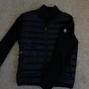 Svart Moncler pufferjacka med dragkedja - Snygg svart pufferjacka från Moncler med quiltad front och ärmar i mjukare material.  Är öppen för att byta också. Skriv om ni har några frågor! MVH/Wille