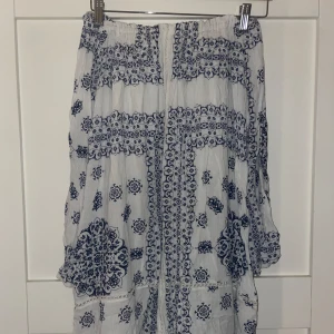 Vit offshoulder klänning med blått mönster - Luftig och flowy klänning i vitt med detaljerat blått mönster. 