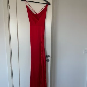 Röd lång klänning - Använd 1 gång, slitsen börjar ganska högt upp. Står ingen storlek men passar mig som är xs/s.