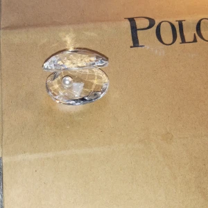 Swarovski kristall snäcka med äkta pärla - Superfin kristallprydnad från Swarovski i form av en snäcka med en vit pärla inuti. Snäckan är slipad och glittrar snyggt i ljuset. Kommer med originalförpackning och blå presentpåse från Swarovski. Perfekt som dekoration eller present. Skriv till mig vid minsta lilla fundering🙌 Nypris är ca 1000 kr. Är ni inte nöjda med priset jag satt är det bara att komma med erbjudande