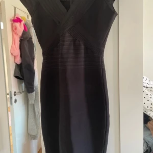 Svart kort klänning från herve leger - Herve Léger klänning. Klänningen har v-ringning, korta ärmar och dragkedja bak. Materialet är stretchigt och figurnära, perfekt för en stilren look. Passar XS perfekt 