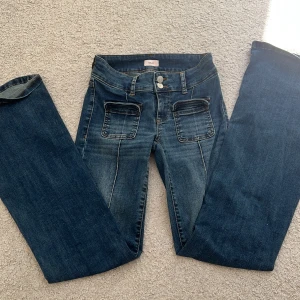 Low waist Bootcut jeans med fickor från Nelly - Snygga blå bootcut jeans från Nelly med låg midja och markerade sömmar framtill. Jeansen har stora fickor fram och klassiska bakfickor. Tillverkade i jeansmaterial med en cool tvättad look och dubbla knappar i midjan. Finns inte längre i Nellys sprtement men köptes för 600kr 👖