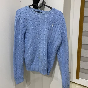 Ljusblå kabelstickad tröja Ralph Lauren - Skit snygg Ralph lauren tröja, storlek L men skulle säga den passar M bättre, och är overzized på någon som har S. Den har fläckar därav priset, priset går att sänka 