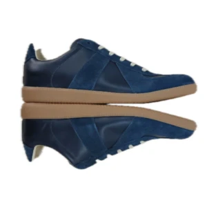 Maison Margiela GAT - Maison Margiela GAT sneakers i djupblå färg med beige gummisula. Snygg mix av mocka och skinn på ovandelen, klassisk rund tå och vita snören. Tillverkade i Italien, levereras med dustbags och box. Perfekt för dig som gillar stilrena och exklusiva sneakers.