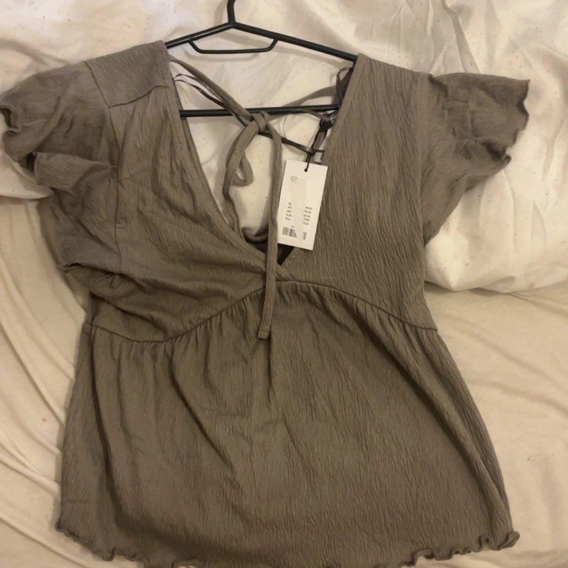 Beige omlottopp med knyt och volang