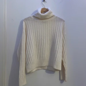Vit ribbad polotröja från Mango - Säljer en supermysig vit polotröja från Mango i storlek S. Tröjan är ribbstickad med hög polokrage och långa ärmar. Pris går att diskutera!