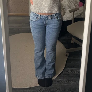 Bootcut jeans med broderade bakfickor - Ett par ljusblå bootcut jeans med låg midja från lager 157 med snygga broderade detaljer på bakfickorna. 