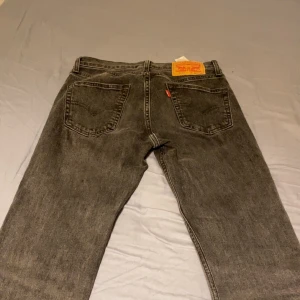 Levi's 511 svarta jeans W28 L32 - Säljer ett par Levi's 511 jeans i svart tvättad denim. Klassisk femficksmodell med rakt snitt och normal passform. Snygga detaljer med Levi's röda logga på bakfickan och läderpatch i midjan. Perfekta till sneakers eller boots.