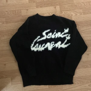 Svart stickad Saint Laurent tröja - Svart stickad tröja från Saint Laurent helt ny aldrig använt säljer för att passformen passar inte mig riktigt bra men tror kommer passa många av er många där ute.