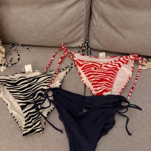 3 bikiniunderdelar från Gina Tricot & H&M - Tre snygga bikiniunderdelar: en svartvit zebramönstrad och en rödvit zebramönstrad från Gina Tricot (båda i M) helt okej skick, samt en marinblå från H&M (strl 40) oanvänd.  Alla har knyt i sidorna och är perfekta för stranden i sommar. 80kr för alla, går att köpa separat för 30kr/st. 