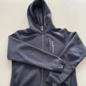 Mörkblå hoodie från Sail Racing - Mörkblå hoodie från Sail Racing med dragkedja. Inga skador 