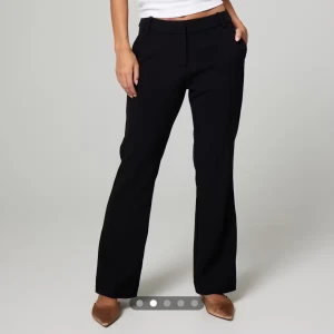Svarta kostymbyxor med bootcut - Snygga svarta kostymbyxor med bootcut-snitt och normal passform. Byxorna har hällor för bälte och klassisk midja. Perfekta för en clean och stilren look. Petite.