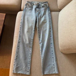 Ljusblå raka jeans från Zara - Ljusblå jeans från Zara med rak passform och råa, avklippta benslut. Klassisk femficksmodell i mjuk bomullsdenim med hög midja. Perfekta för en avslappnad och trendig look. Passar mig som är 163cm