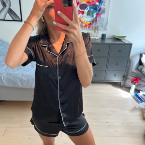 Svart sidenpyjamas med vita detaljer - Snygg svart blus och matchande shorts. Perfekt för en avslappnad look, så mysig. 