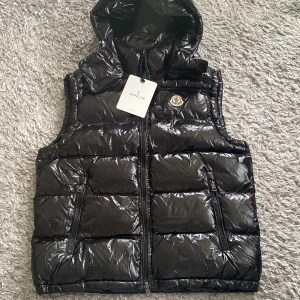 Svart Moncler vest med luva - Säljer en svart Moncler vest med huva. Helt ny och oanvänd, med tags och allt 