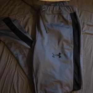 Under Armour byxor  - Snygga grå brallor från Under armor byxor. Sköna och stilrena med normal passform. Passar dig omkring 180cm