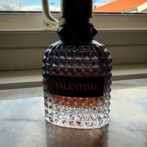 Valentino Coral Fantasy  - Säljer en lyxig parfym från Valentino, flaskan har ungefär 40ml kvar av 50ml. Flaskan är transparent med nitar och har en cool struktur, svart etikett och svart kork. Innehållet är svagt rosa. Perfekt för dig som gillar exklusiva dofter och snygg design med många komplimanger.