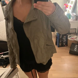 Olivgrön bikerjacka från Gina Benotti - Snygg olivgrön bikerjacka från Gina Benotti med coola detaljer som sned dragkedja och quiltade axelpartier. Jackan har två fickor med dragkedja och klassisk krage. Perfekt för dig som vill ha en stilren och edgy look. Har köpt denna från Sellpy men inte använt, skulle säga att den ör i bra skick men har tecken på slitningar i nacken och vid axeln. Själv tycker jag det det ser coolt ut men så ni vet!☺️😇 Köpte jackan för ca 200 och väljer att sätta lägre pris pga skadorna.