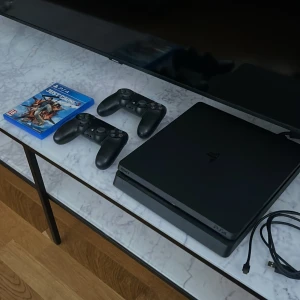 Playstation 4 - Sony Playstation 4 slim med två dualshock handkontroller. Konsolen fungerar felfritt, kommer med original tillbehör och inkluderar ett spel.  Finns i Uppsala/Stockholm, annars står köparen för frakten. 