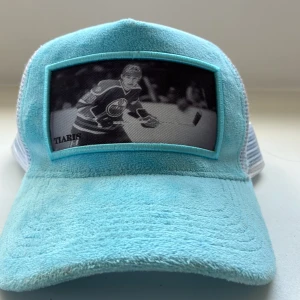 Turkos keps med hockeymotiv - Hockey keps från tiaris med tryck av Wayne gretzky och denna produkt är linted edition såld