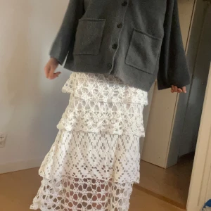 Vit långkjol med virkad spets - köpt på en marknad i spanien🥰Den är väldigt stor i storleken så jag har använt en säkerhetsnål när jag haft på mig den vilket funkat bra😇🙌Alltså kan alla från xs-xxl ha på sig den enligt mig💖🥰Superfin vit långkjol med flera lager virkad spets och genombrutet mönster. Kjolen har en bohemisk vibe och sitter snyggt i midjan. Perfekt för dig som gillar romantiska och unika plagg med mycket detaljer.🔥🙌😍