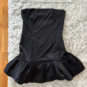 Svart kort klänning - Jättefin kort bandeau klänning från Peppermayo. Tyvärr passar den inte riktigt mig därav säljer jag den. Aldrig använd.