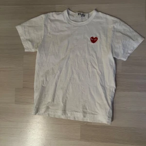 Vit Comme des Garçons Play t-shirt - Vit t-shirt från Comme des Garçons Play med det ikoniska röda hjärtat, storlek M men sitter mer som S, använd endast fåtal gånger, nypris 995 kr, mitt pris 450  