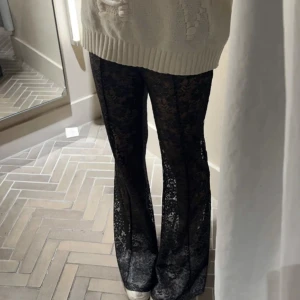 Svarta spetsbyxor med bootcut - Säljer ett par svarta byxor i genombruten spets med utsvängda ben. Lånad bild!! Passar stl xs-m. Lite sönder längst ner vid foten, skicka privat för egna bilder! 