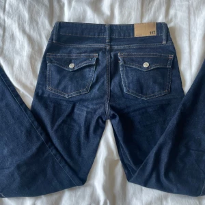 Mörkblå jeans från 157 med bootcut - Snygga mörkblå jeans från lager 157 som är i stl XS men passar jätte bra mig som är 173cm!!! . Modellen har bootcut-ben och normal passform. Jeansen är tillverkade i ett mjukt bomullstyg med lite stretch för extra komfort. 