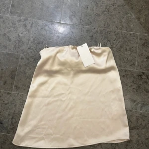 Champagnefärgad bandau topp från Zara - Satintopp som är bandau från Zara! Populär och helt slutsåld ❤️små defekter, men ny med lappen kvar!!
