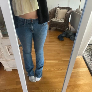 Blå bootcut jeans från Zara low waist - Säljer ett par klassiska blå jeans från Zara i bootcut-modell. Jeansen har normal passform, fem fickor och stängs med knapp och dragkedja. Tillverkade i jeansmaterial med lätt stretch. Perfekta till sneakers eller boots.