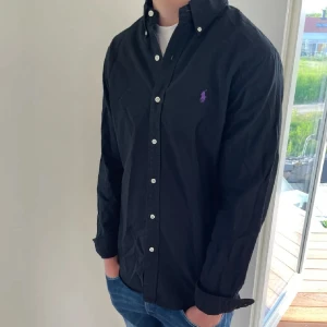 Svart Ralph lauren skjorta  - Hej säljer nu min fina Ralph lauren skjorta i storlek L. Den är i bra skick och kommer vara otroligt snygg nu i vår och framåt sommaren. Nypris cirka 1600kr! Vi kommer att sälja liknande produkter nu i vår och närmare sommar så glöm inte följa profilen!🌊🍾 3