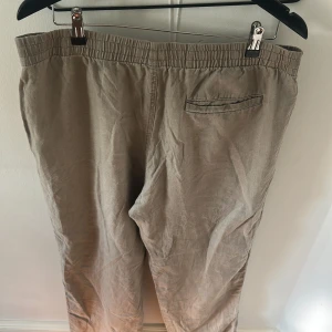 Beige linnebyxor med snörning, L - Helt vanliga beiga linnebyxor från Hm, storlek L. Knappt använda så väldigt bra skick, bara att göra av sig vid frågor.