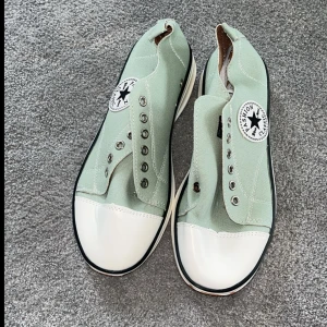 Mintgröna sneakers - Snygga mintgröna sneakers med vit tå och svart/vit sula. Skorna har klassisk rund tå, metallöljetter för snörning och tygpatch på sidan. Perfekta för dig som gillar en clean och stilren look med retrovibbar. Aldrig använda 