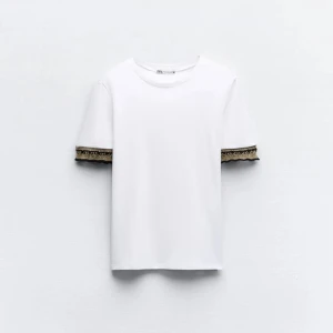 Vit t-shirt med spetsdetaljer från Zara - Säljer en vit T-shirt från Zara. ‼️KOLLA ANDRA BILDEN FÖR ATT SE HUR SPETSEN SER UT‼️ för jag hittade ingen bild på hur hela tröjan exakt såg ut och hade ingen möjlighet att ta bild på hela tröjan💕inte använd alls mycket då den inte passade.