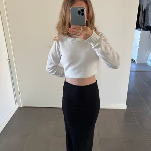 Svart långkjol från Gina Tricot - Snygg svart långkjol från Gina Tricot i en tight passform. Kjolen är enkel och stilren, perfekt för olika tillfällen. Den är gjord i ett mjukt och bekvämt material som formar sig fint efter kroppen.