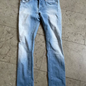 Ljusblå jeans från Replay - Snygga ljusblå jeans från Replay med en klassisk femficksdesign. De har en normal passform och är perfekta för en avslappnad stil. Jeansen har en lätt tvättad look som ger dem en cool vibe. 