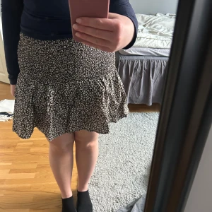 Kjol - Svart smockad kjol med vita blommor på🌸