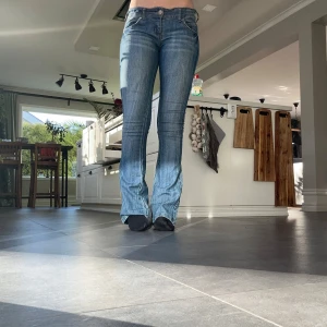 Blå bootcut jeans - Snygga blå bootcut jeans med väldigt låg midja.  Perfekta för en avslappnad stil med en touch av retro. har även ett insytt resor band, star att det är storlek 40/L men den är mer en större 36