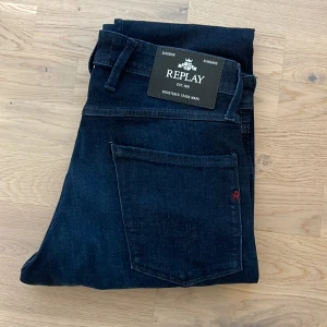 Mörkblå jeansbyxor från Replay - Snygga mörkblå jeansbyxor från Replay i modellen Anbass. De har en slim fit passform och klassisk femficksdesign. Perfekta för en stilren look. Skick 10/10. Priset kan diskuteras vid snabb affär! Skriv vid frågor!