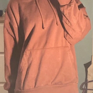 Roströd oversized hoodie - Säljer en bekväm brun hoodie med en stor ficka framtill och justerbar huva. Perfekt för en avslappnad stil. Passar bra till jeans eller mjukisbyxor.
