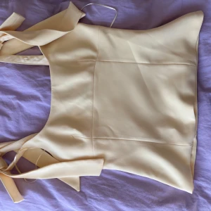 Ljusgul topp med knytband slutsåld Zara - Snygg ljusgul topp med knytband vid axlarna. Perfekt för sommarens alla tillfällen. Den har en enkel och stilren design som gör den lätt att matcha med olika accessoarer. Oanvänd då jag beställde två storlekar💛