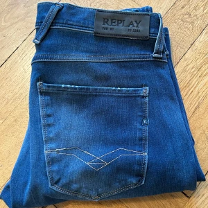 Blå jeans från Replay - Ett par feta blå jeans från Replay i modellen Anbass🙌 De har en klassisk femficksdesign och en bekväm passform. Perfekta för en stilren look🤩.